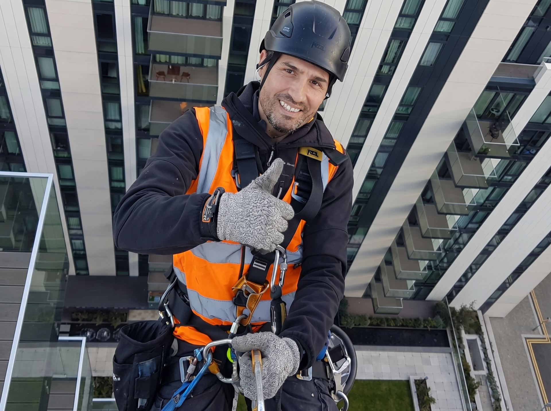 Rope access technician working on a high-rise glass façade